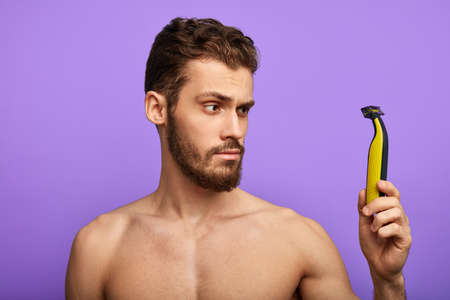 cares about hygiene, man is checking a new shaver in the morning. close up photoの写真素材