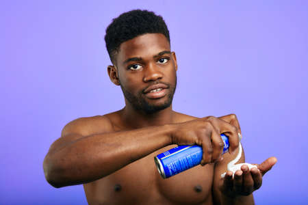 attractive young man applying shaving foam on the palm and looking at the camera.cosmetic, mans...