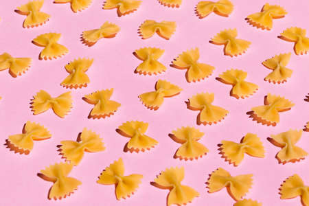 bow tie pasta isolated on pink background. top view
