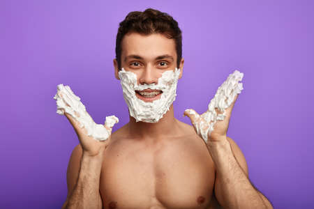 happy young crazy nacked guy with smeared face expresses his delight with wifes present on Faters day.close up photo.の写真素材