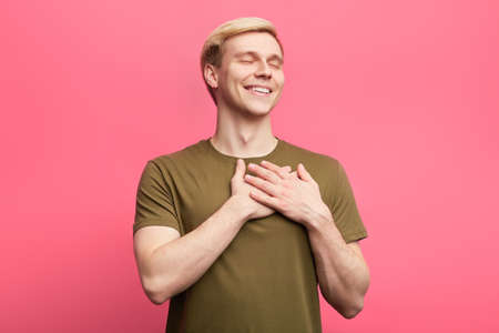 romantic cheerful man falls in love. happiness concept. young cheerful man having love disease. I appreciate it. thank you. with all my heartの写真素材