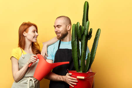 happy positive florists with watering can posing to the camera, job, profession, occupation, copy...