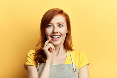 young attractive excited girl with a finger on her lips making up a great business plan. I have idea. dream.の写真素材