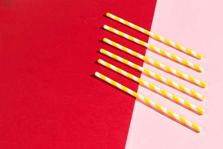 different drinking straws over pink and red background, top view. copy spaceの写真素材