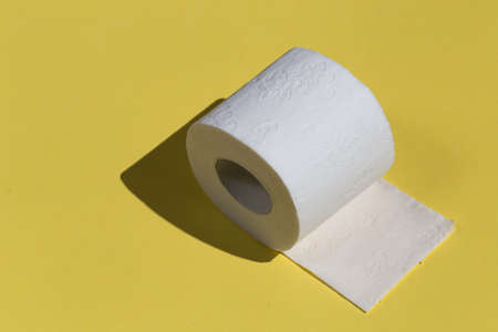Roll of toilet paper or tissue isolated on yellow background. close up photo. copy spaceの写真素材