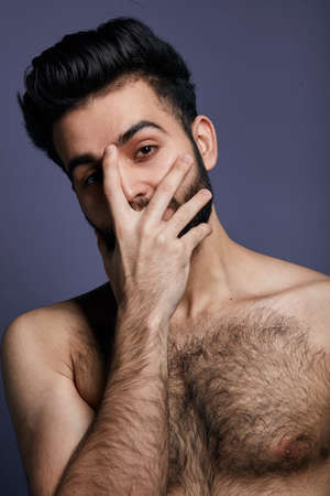 Handsome awesome man looking through fingers with embarrassed expression at the camera. guy whith a palm on his face, posing to the camera. Oh, my God,isolated blue backgroundの写真素材