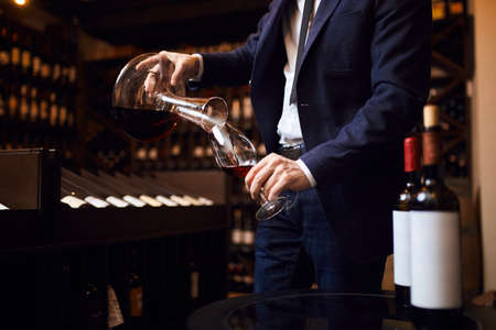 young man mixing wines. creation of unforgettable wine. art concept. close up cropped photoの写真素材