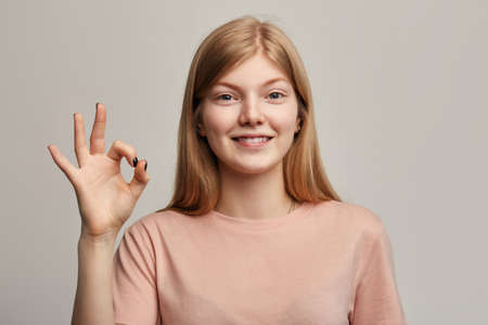 pleasant excited woman with beaming smile showing ok sign. gesture concept. everything is ok. close...