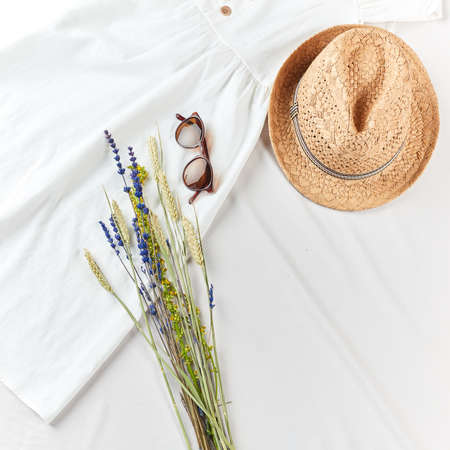 bunch of field flowers on white dress. summer mood, prepration for summer holiday. top cropped photo. sale conceptの写真素材