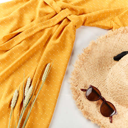 Wheat,straw hat, yellow stylish dress on light white background. Flat lay, top view, copy space, copyspace. autumn mood, atmosphereの写真素材