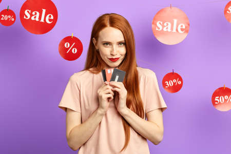 Happy beautiful awesome woman holding cards isolated on blue background.close up portrait. isolated blue background. studio shotの写真素材