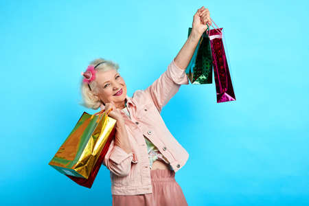 pretty granny has bought presents, clothes for her granddaughters and grandsons. close up portrait....