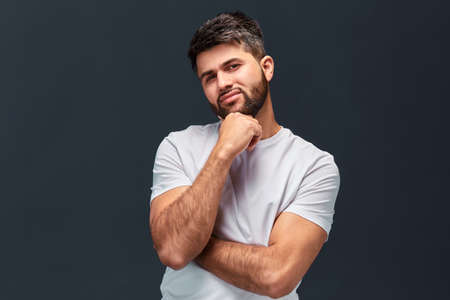 attractive guy thinking about his business, isolated grey background, studio shot. facial expression, free time, spare time, restの写真素材