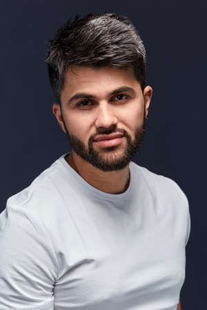 attractive cool sexy Arab guy posing to the camera, isolated black background, lifestyle, free time,...
