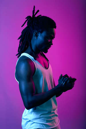 confident serious pensive thoughtful man making decision, solving a problem, keeping hand together, close up side view portrait, violet background, studio shotの写真素材