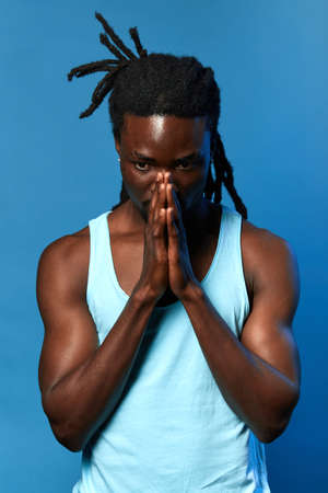 sad unhappy depressed guy has bad mood. he wishes to recover from ilness, desease, close up portrait, isolated blue background, studio shotの写真素材