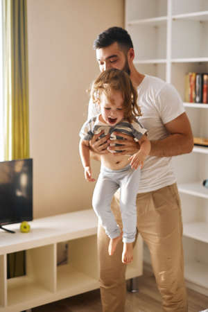 elder brother keeping his little sister, making her laugh, close up photo, happiness, positive feeling and emotionの写真素材