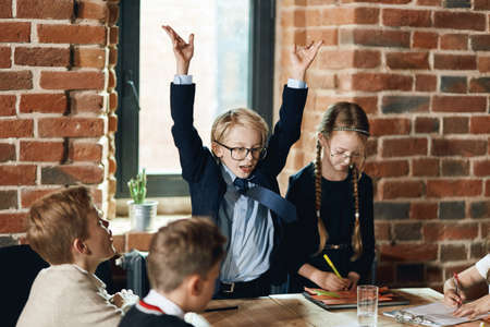 boy with raised arms explaing the growth of business to colleagues, close up photo. gesture conceptの写真素材