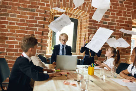 business team sitting at the table while documents are flying above the desk, business concept
