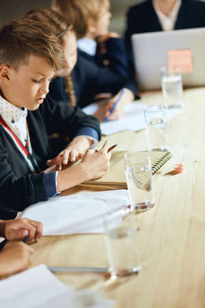 little office workers writing something on sheets of paper while boss giving recommendations how to run business, workshop,の写真素材