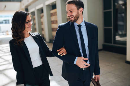 young man and woman laughing at each other while going to the meeting, happiness, positive feeling...