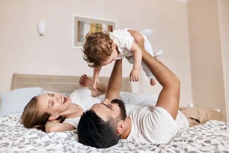 positive couple entertaining their babym sining songs to her. close up photo, relationship, happy...