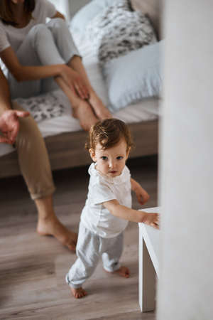 lovely little girl leaning on the table, learning to go at home.の写真素材