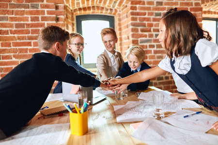 young business children showing team work and keeping hands together in office. Teamwork concepts.