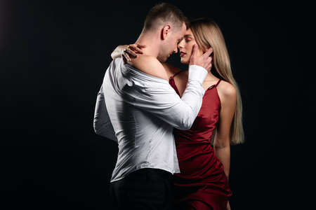 dirty dance. couple hugging and kissing in the studio with black wall, isolated background.desire...