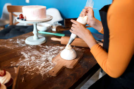 young housewife learning to bake cupcakes, close up cropped photoの写真素材