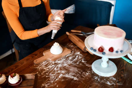 woman working at bakery, close up cropped photo, dessert with delicious flavor