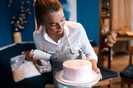 serious talented girl concentrated on cooking, learning to bake cake, close up photo