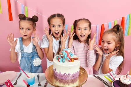 little beautiful girs screaming with joy at birthday party, happiness, positive feeling and emotion, isolated pink background, studio shot.の写真素材