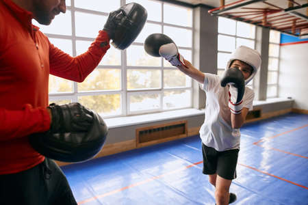 kid trying to hit his opponent during workout, boy with stretched arm performing hit. close up cropped photoの写真素材