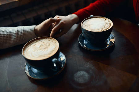 best latte for best people. evening with boyfriend and tasty flat white. closeup cropped side view photo. latte art.の写真素材