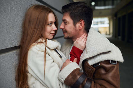 young beautiful passionate girl touching her boyfriends neck going to kiss him. close up side view...