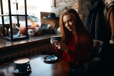 young pretty girl is fond of drinking cappuccino, close up photo, free time, spare time, lifestyle,...