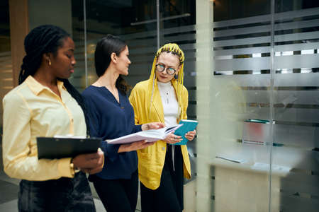 three beautiful business women walking in the office and discussing project, idea, plan. close up...