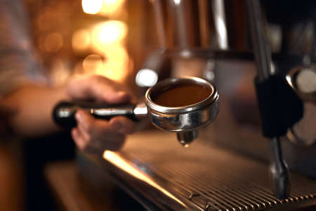 man's hand holds a portafilter with ground coffee.close up side view photo, secret of making perfect coffeeの写真素材