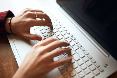 Corporate male using laptop, typing business report. Cropped image.guy surfing, browsing the net....