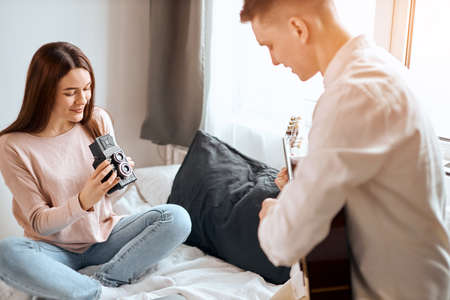 awesome girl sitting with croosed legs using the camera shooting her husbands song . close up photo,...