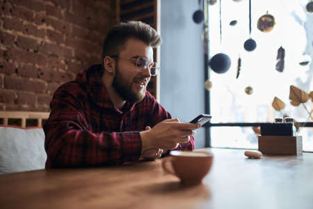 happy bearded guy in eyeglasses chatting with girlfriend in the cafe. close up side view photo. conversation with clients, customers.job, professionの写真素材