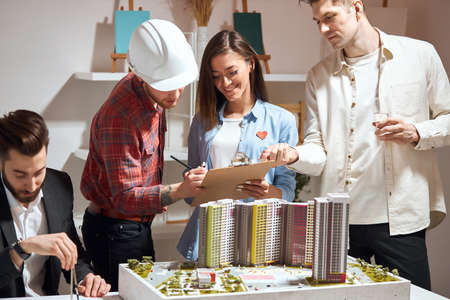 excited group of young architects collaborating on common project working in friendly atmosphere in the office with modern interior.の写真素材