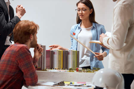 awesome beautiful talented woman holding a ruler and explaining the features of new project in the...
