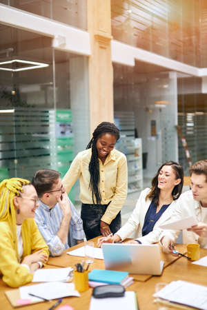 young stylish colleagues telling jokes, having fun, vertiacl shot. happiness, positive feeling...