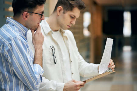Portrait of two clever businessmen brainstorming in the office. close up side view photo. job, profession, occupationの写真素材