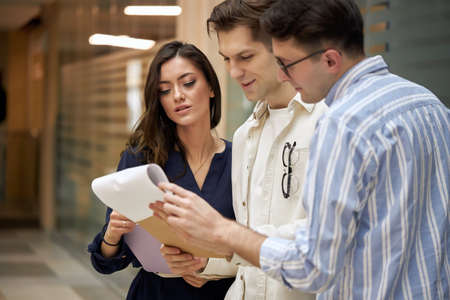 awesome active business people discussing contract, document, brunette woman in elegant blue sty...