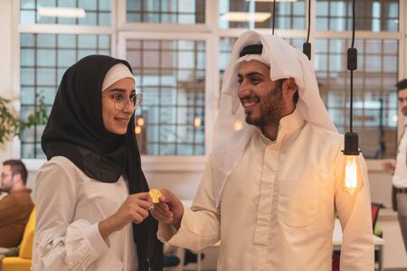 Muslim hijab woman share bitcoin with arabian businessman. Cryptocurrency concept.のeditorial素材