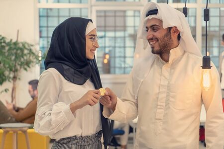 Muslim hijab woman share bitcoin with arabian businessman. Cryptocurrency concept.のeditorial素材
