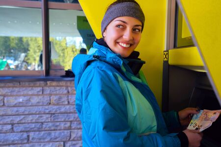 the girl raises money from the ATM - Imageの写真素材